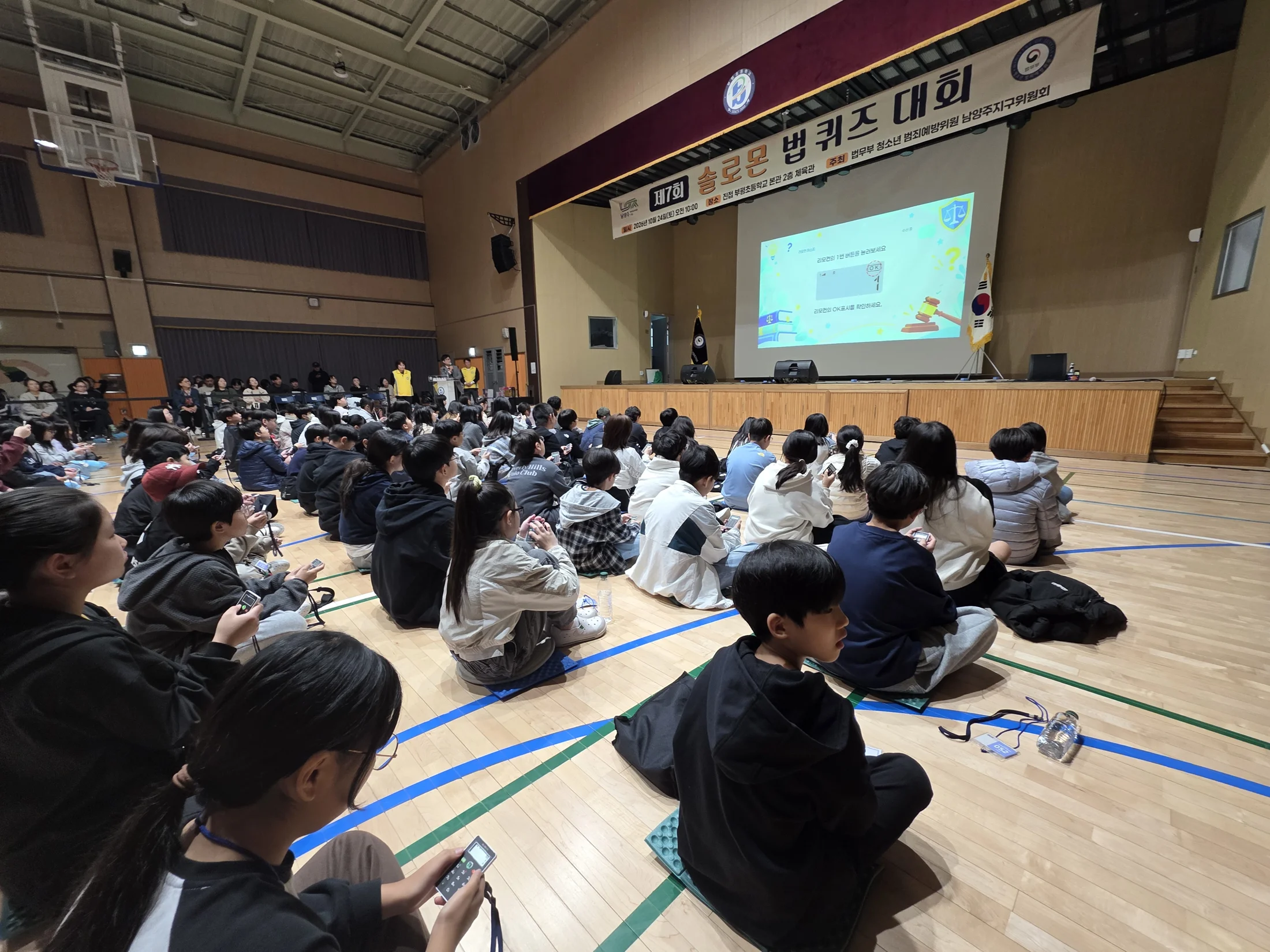 리모컨 사용 안내 화면을 보며 입력을 확인하는 참가자들